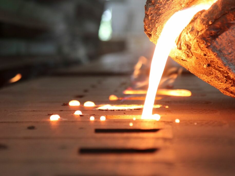 Molten metal being precisely poured into a sand mold during the non-ferrous casting process. High-temperature metal casting ensures durable, high-quality components for aerospace, automotive, and industrial applications.