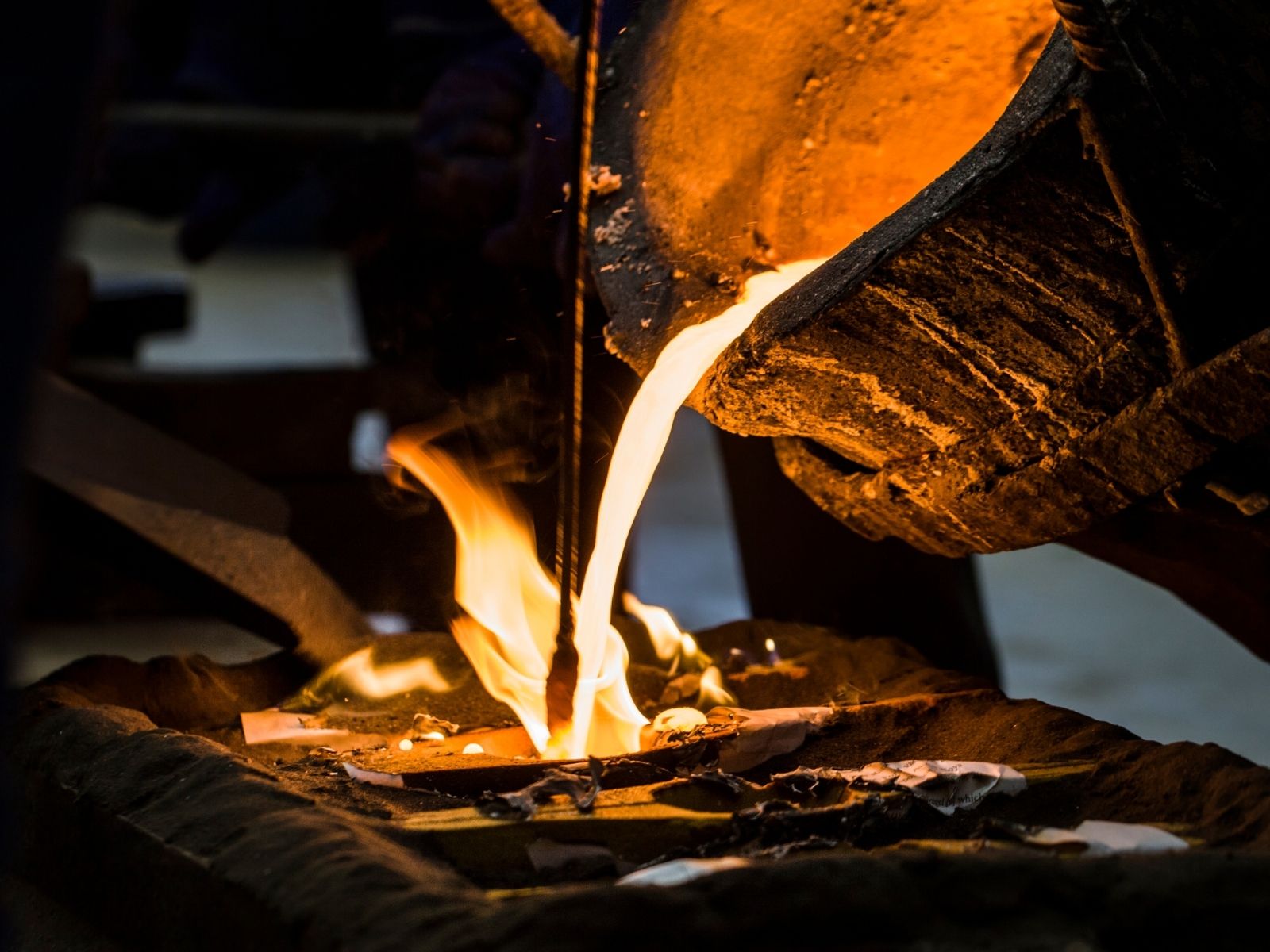 Molten metal being poured into a mold in an industrial foundry, showcasing the precision metal casting process. High-temperature liquid metal flows with sparks and flames, highlighting expert craftsmanship and advanced manufacturing techniques. Non-ferrous metal casting for aerospace, automotive, and industrial applications.