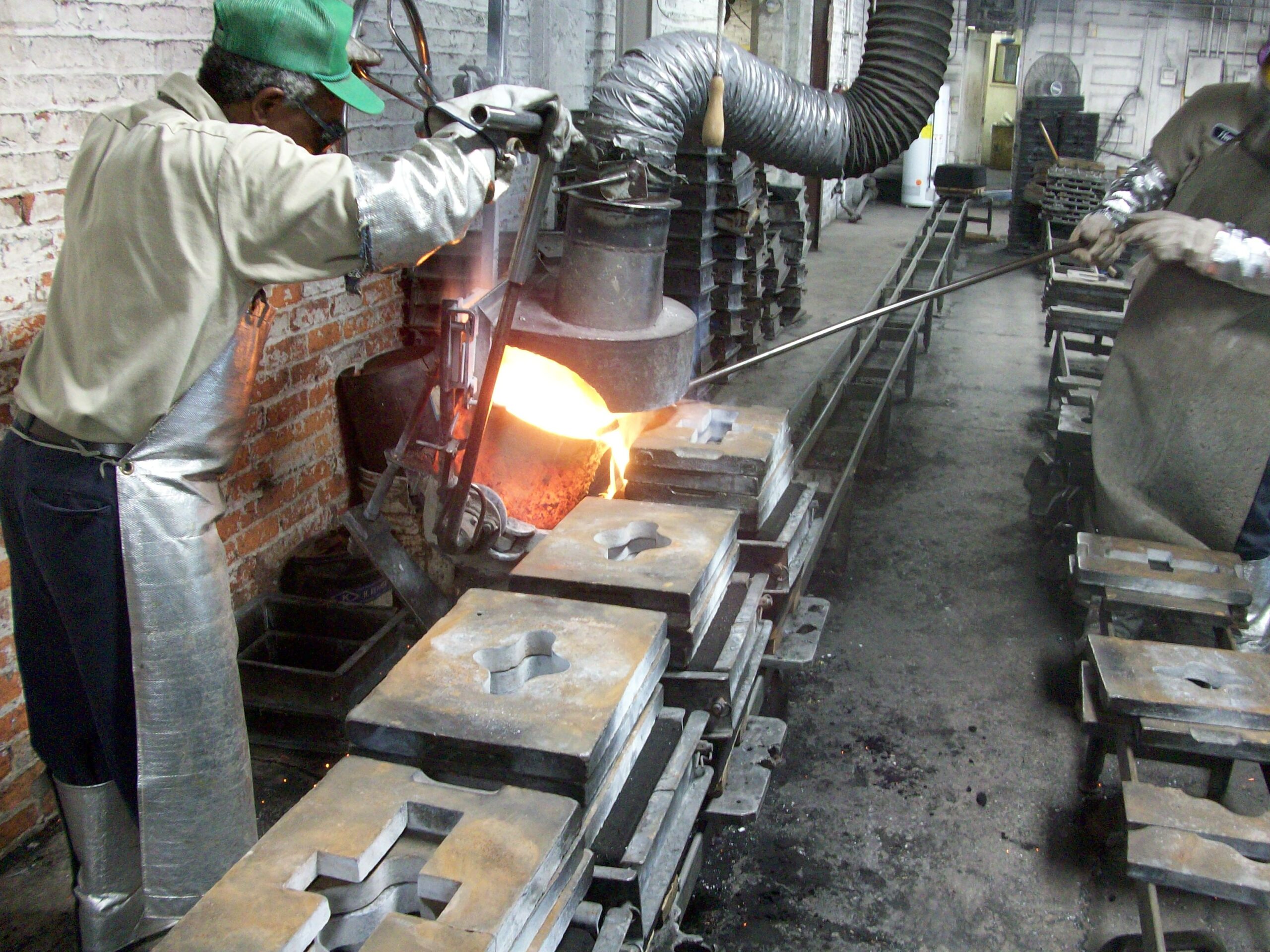 Skilled foundry workers pouring molten metal into sand molds during the precision casting process. Non-ferrous metal casting ensures high-quality, durable components for aerospace, automotive, and industrial applications.
